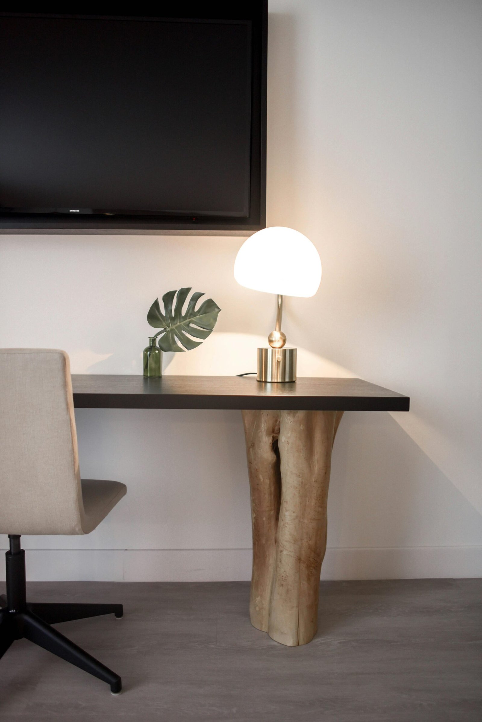 Elegantly designed modern workspace featuring a unique wood table, chair, and lamp.